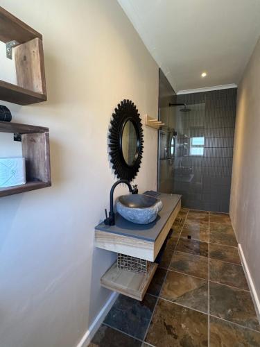 a bathroom with a sink and a mirror at Mes Amis Beach Guest House in Wilderness