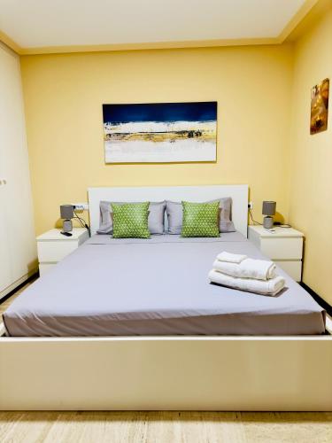 une chambre avec un grand lit blanc avec deux tables de nuit dans l'établissement Habitación Baño Privado, TV y Netflix, à Alicante