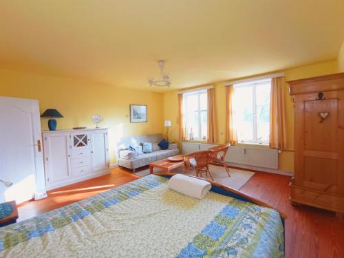 a bedroom with a large bed and a couch at Ferienwohnung "Altes Pastorat" in Welt