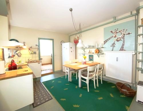 a kitchen with a table and chairs in a room at Ferienwohnung "Altes Pastorat" in Welt