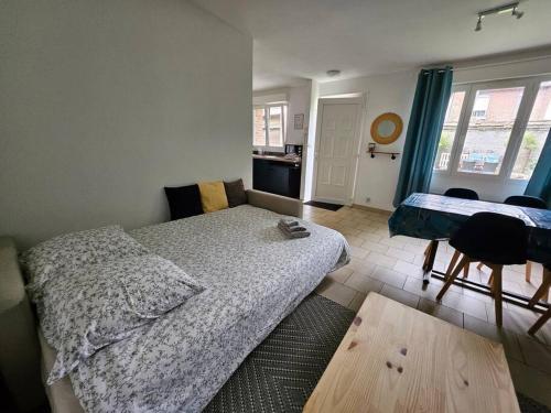 una camera da letto con un letto, un tavolo e una cucina di La Maisonnette a Haubourdin