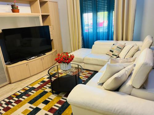 a living room with white furniture and a flat screen tv at Residenza Cinisello Balsamo Milano in Cinisello Balsamo