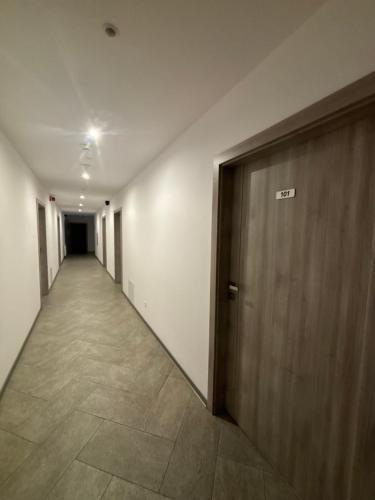 an empty hallway with a wooden door in a building at Apartament Residence Nysa in Nysa
