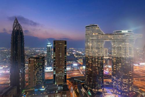 a city skyline with tall buildings at night at Skyline Views 2BR Near Burj Khalifa & Dubai Mall with Pool Access in Dubai