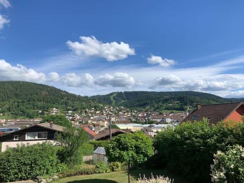 a town with houses and mountains in the background at Maison avec jardin Gérardmer L'AUTOUR in Gérardmer