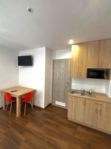 a kitchen with a wooden table and a sink and a counter at Apartament Residence Nysa in Nysa
