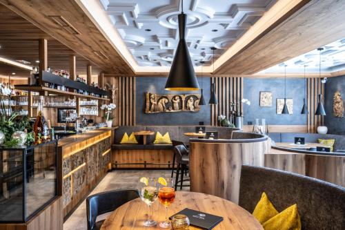 a restaurant with a wooden table and chairs and a bar at Wellness Hotel Gran Risa***S in La Villa