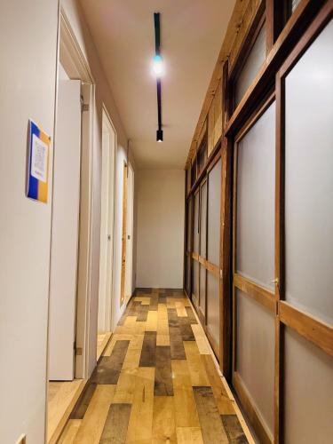 an empty hallway with wood floors and a door at ゲストハウスSLOW HOUSE okuizumo in Minarimachi