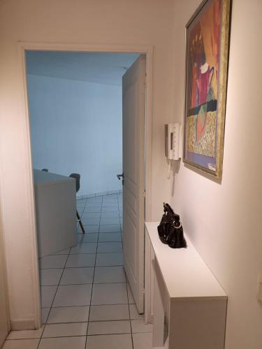 une pièce avec un couloir avec un sol en carrelage blanc dans l'établissement Chambre Dans appartement partagé, à Roquebrune-Cap-Martin