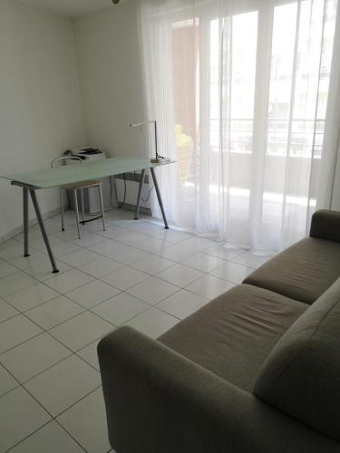 un salon avec un canapé et une table dans l'établissement Chambre Dans appartement partagé, à Roquebrune-Cap-Martin