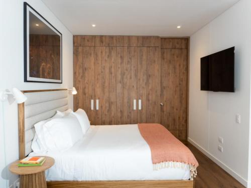 a bedroom with a bed and a tv on a wall at Art Homes 85 in Bogotá