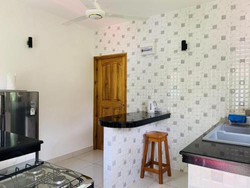 a kitchen with black counter tops and a stove at Oceanic View Apartments in Beau Vallon