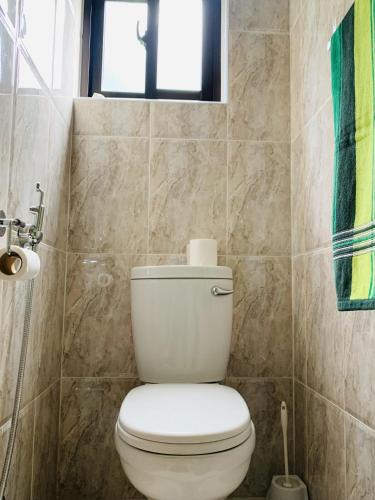 a bathroom with a white toilet and a window at Oceanic View Apartments in Beau Vallon