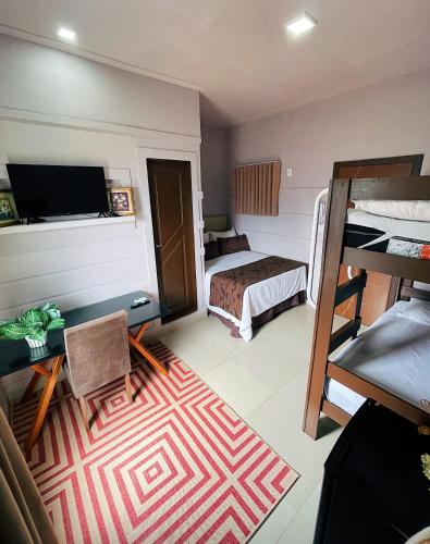 a room with a bedroom with a bed and a desk at Studio Bangalô Belém Hospedagem in Belém