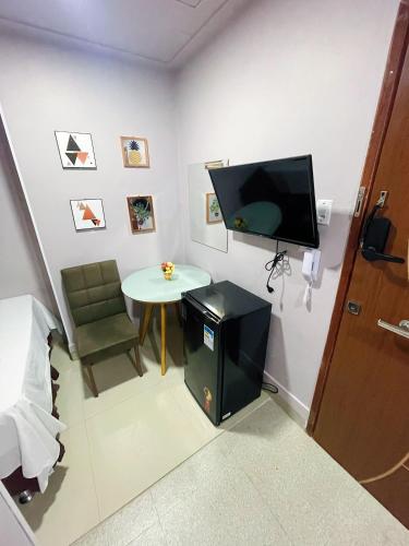 a room with a small table and a tv on the wall at Studio Bangalô Belém Hospedagem in Belém