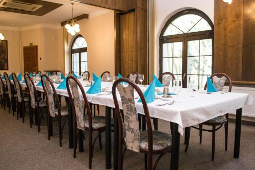 une salle de conférence avec une longue table et des serviettes bleues dans l'établissement Hotel Širák, à Most