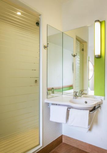 a bathroom with a sink and a mirror at Cambridge Hotel Bradford Central in Bradford
