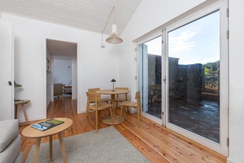 a living room with a table and a large window at Sea Vine - Azores Eco Lodging in Cais do Galego