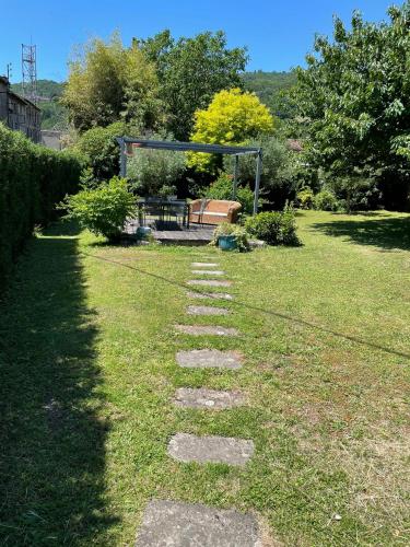 a stepping stone path in a yard with a bench at Residence le Petit Paradis in Labastide-Rouairoux