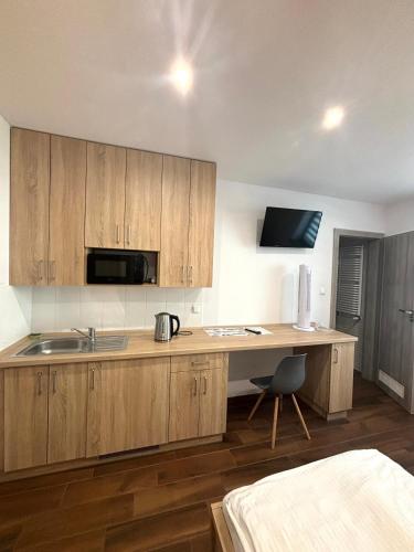 a kitchen with wooden cabinets and a desk with a sink at Apartament Residence Nysa in Nysa