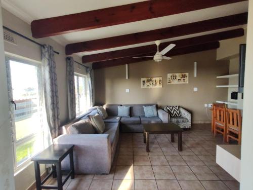 a living room with a couch and a table at Chakas Rock Chalets - Unit 19 in Ballito