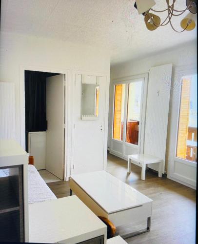 a white room with two beds and two windows at Charmant logement 4 personnes in Lans-en-Vercors