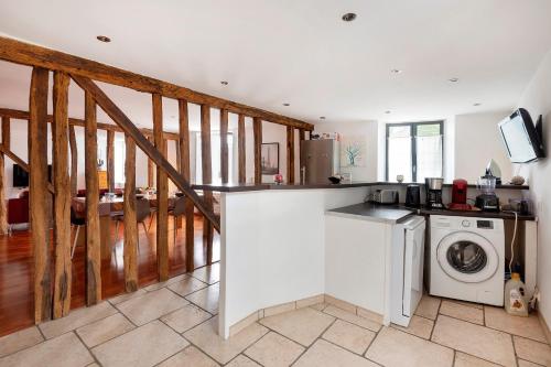une cuisine avec une machine à laver et un lave-linge dans l'établissement Gîte du Clocher - Appt 6p avec terrasse, à Moissy-Cramayel