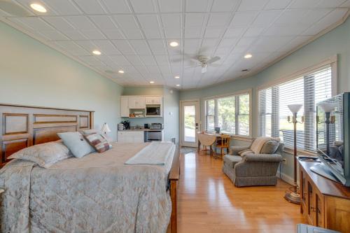 a bedroom with a large bed and a kitchen at 4 Mi to German Village Studio with Hot Tub! in Millersburg
