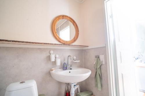 a bathroom with a sink and a mirror at Arctic Hearts - Kleines Schwedenhaus im Wald am See in Jörn