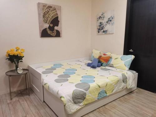 バギオにあるRelaxing 1-BR at City Center Goshen Land Towersの掛け布団が敷かれたベッドのある寝室