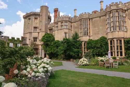 an old castle with a garden in front of it at Thornbury Castle - A Relais & Chateaux Hotel in Thornbury