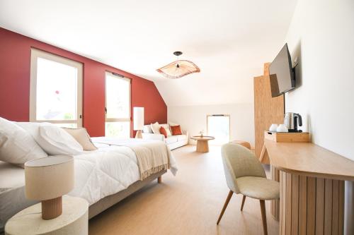 a bedroom with a bed and a desk with a television at Le Clos des Cadoles in Les Riceys