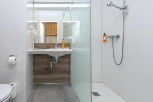 シェンナにあるAparthotel Apartamenty Czarna Góra 138のガラスのシャワーと洗面台を備えたバスルーム