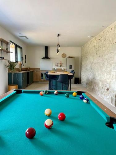 a pool table with balls on it in a room at Bâtisse au cœur du Gers in Leboulin