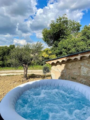 a large bath tub in a yard with trees at Bâtisse au cœur du Gers in Leboulin