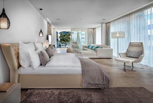 a bedroom with a large bed and a living room at Eden Reserve Hotel in Gardone Riviera