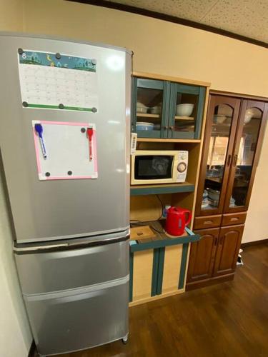 a kitchen with a refrigerator with a calendar on it at Grace House グレイスハウス- Country Home Relaxation in Okawa