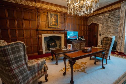 a living room with a table and a fireplace at Thornbury Castle - A Relais & Chateaux Hotel in Thornbury
