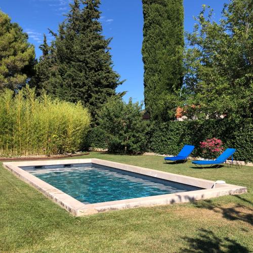 - une piscine dans une cour avec 2 chaises bleues dans l'établissement The HoPe, suite privée au sein d'une maison avec piscine, à Aix-en-Provence