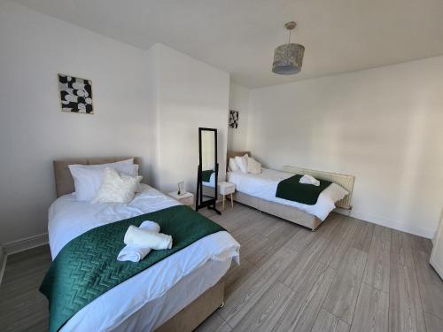 1 Schlafzimmer mit 2 Betten und einem Teddybär auf dem Bett in der Unterkunft The Greenhouse near Leeds City Centre in Killingbeck