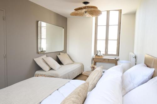 a bedroom with two beds and a couch and a mirror at Le Clos des Cadoles in Les Riceys