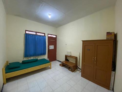 a room with a bed and a cabinet in it at Hong Kost Homestay Putra Csb Mall in Cirebon