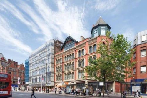 a building on a city street with a bus at Boutique City Centre Flat by City SuperHost in Manchester