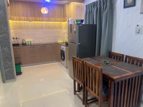 a kitchen with a table and a refrigerator at Areia De Goa, Comfort Stay Apartment near Baga Beach in Baga