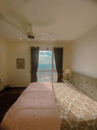 a bedroom with a large bed with a large window at 01 BHK CONDO IN FRONT OF CENTORUs in Islamabad