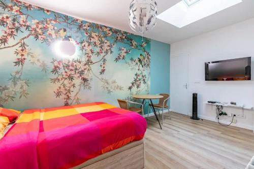 - une chambre avec un lit coloré et une table dans l'établissement Gare du Nord Confortable pied à terre avec patio, à Paris