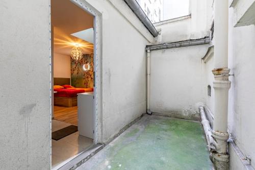 une porte ouverte menant à une chambre avec un canapé dans l'établissement Gare du Nord Confortable pied à terre avec patio, à Paris