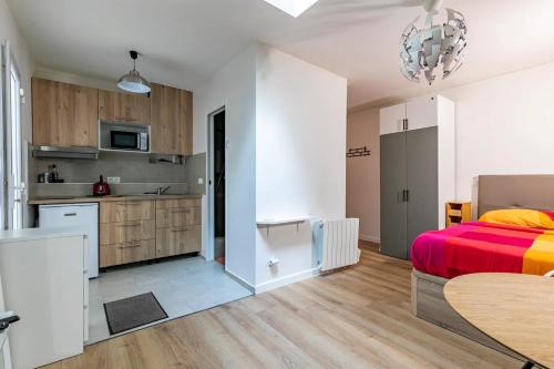 une cuisine et une chambre avec un lit et une table dans l'établissement Gare du Nord Confortable pied à terre avec patio, à Paris