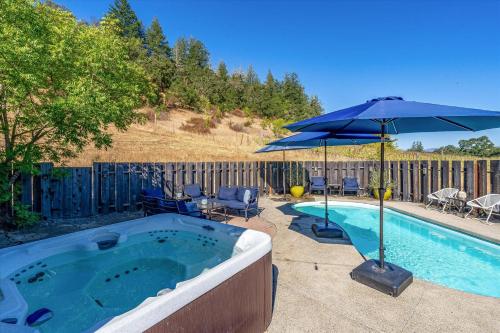 a hot tub with an umbrella and chairs and a table at Calistoga Vineyard Getaway A Wine Country Escape in Calistoga