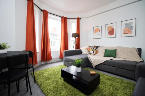 a living room with a couch and a table at 2 Bed Flat near Stadium with Street Parking by CTO Serviced Apartments in Cardiff